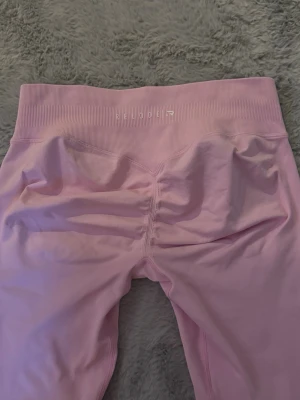 Rosa leggings  - Snygga rosa leggings från Relode med mid waist och scrunch-detalj bak. Använd 1 gång och tvättade, säljer då dom är lite för stora för mig. Nypris 699kr 