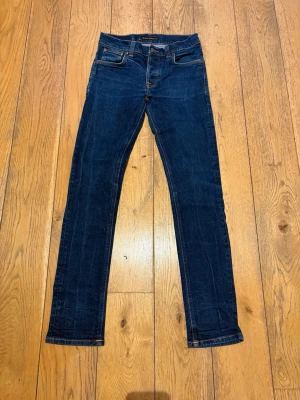 Nudie Jeans Grim Tim - Säljer ett par riktigt feta Nudie jeans av modellen Grim Tim som är i mycket bra skick, har ljusnat lite vid grenen men syns knappt när byxorna används. Sjukt bra passform och de är w31 som står i byxorna. De är L34 i längd. Riktigt feta och mycket fräscha. Hör av er vid frågor. 
