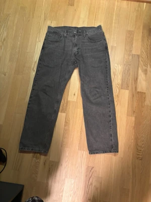 Grå raka jeans Levis 555 W33 L30 - Säljer ett par grå jeans med rak passform och klassisk femficksdesign. Jeansen har normal midja och är tillverkade i denim. Perfekta för en avslappnad och stilren look. Levis modell 555 W32 L30. Hör gärna av om pris. 