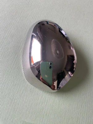 Silvrig metallisk hårklämma - Säljer en cool, spegelblank hårklämma i silverfärgad metall med organisk, rundad form. Klämman har en robust spännanordning på baksidan som håller håret på plats. Perfekt för dig som gillar minimalistisk och futuristisk stil.