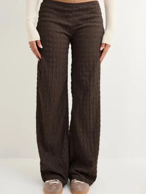 Bruna byxor från nelly - Sköna bruna mjukisbyxor med vid passform och strukturmönster i tyget. Byxorna har låg midja och långa ben. Materialet är mjukt och stretchigt för extra komfort.
