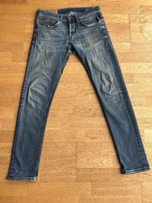 Dondup Jeans - Snygga blå slim fit jeans med lätt slitna detaljer. Jeansen har en något tvättad look och raka ben. Materialet är bomull med lite stretch för extra komfort. Jeansen är i storleken 31. Hör av dig vid frågor!