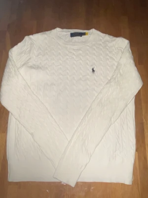 Vit stickat tröja Polo Ralph Lauren - Säljer denna stickade tröja från Polo Ralph Lauren eftersom att den inte passar mig och den gör ingen nytta i min garderob. Storlek L men den passar som M. Pris kan sänkas vid snabbaffär. Helt ny oanvänd, har bara blivit testad. Jätte skön synd att den är för liten bara. 