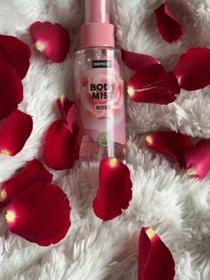 Sence Body Mist Rose - Fräsch body mist från Sence med doft av ros. Flaskan är transparent med rosa detaljer och har en sprayfunktion. Perfekt för dig som gillar blommiga och lätta dofter. Materialet är plast och designen har en romantisk känsla med ros-motiv.💕