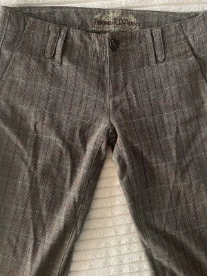 Rutiga kostymbyxor från Freeman T. Porter - Snygga kostymbyxor i grått med diskret rutmönster och raka ben. Byxorna har hällor för bälte, knapp och gylf framtill samt fickor både fram och bak. Materialet känns lätt och passar perfekt till en dressad look.🤗Om ni har frågor eller vill ha flerbilder, exakta mått är det bara och skicka!💕