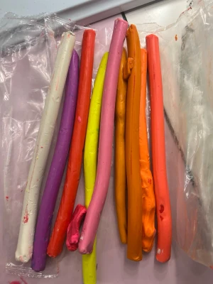 Färgglad modellera i olika färger - Säljer ett gäng modellera i flera olika färger som lila, vit, röd, gul, rosa, orange, brun, svart, grön, blå och grå. Perfekt för kreativa projekt, pyssel eller skulptur. Leran är formbar och kommer i långa stavar. Passar dig som gillar att skapa och experimentera. Leran torkar inte och om den är lite torr så ska man bara värma den så blir den som ny