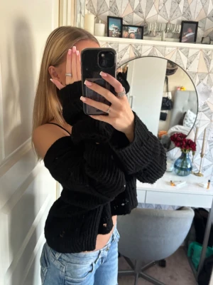 Svart oversized stickad tröja - Säljer en svart, stickad tröja med oversized passform och stora ärmar. Tröjan har ett hålmönster som ger en fet look och är perfekt att styla med jeans eller kjol. Materialet känns mjukt och stretchigt samt kliar den inte! Den är sparsamt använd och är i mycket bra skick❤️‍🔥🤩