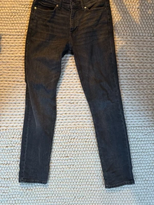 Mörkgråa slim fit jeans - Säljer ett mörkgråa jeans med  klassisk femficksdesign. Jeansen har smal passform hela vägen ner. Perfekta för nån som gillar slim men inte skinny. 