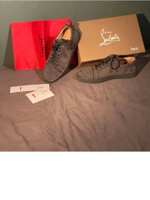 Gråa Louboutin sneakers i mocka - Strl 42. Säljer dessa ”nakna” utan box osv. Endast skorna