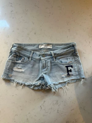 Ljusblå jeansshorts Abercrombie - Säljer ett par ljusblå jeansshorts från Abercrombie & Fitch med slitna detaljer, W25. 