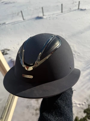 Lamicell Ridhjälm - Marinblå Lamicell ridhjälm. Ej tvättad på bilderna, men tvättas såklart vid köp. Storlek M (52-56cm). Godkänd. Får med ett extra innerfoder.