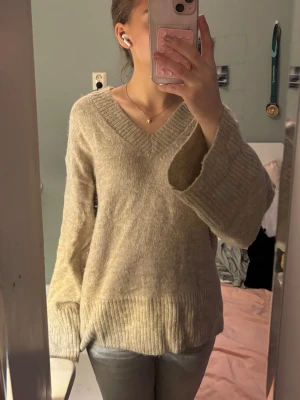 Beige stickad tröja Gina Tricot - Mysig beige stickad tröja från Gina Tricot med v-ringning och bred ribbad kant vid ärmslut och nederkant 💗