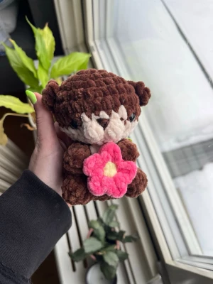 Virkad mörkbrun utter🤎🩷 - Supersöt virkad mini-utter som håller i en rosa blomma.🦦🩷