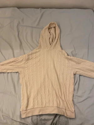 Beige stickad hoodie från H&M - Säljer en beige stickad hoodie från H&M i storlek 158/164. Hoodien har ett snyggt kabelstickat mönster, ribbade muddar och en mjuk huva. Perfekt för dig som gillar en chill och stilren look. Materialet känns mjukt och skönt mot huden.
