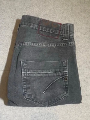 Grå jeans  - Snygga grå jeans med klassisk femficksdesign och raka ben. Jeansen har diskreta slitningar och detaljer i metall vid fickorna. Perfekta för en avslappnad och trendig look. Materialet är denim i bomull. Pris kan diskuteras!