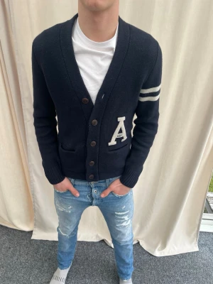 Cardigan från Abercombie & Fitch  - Riktigt snygg cardigan från Abercombie & Fitch. Strl S, personen på bilden är 183 cm lång. Skicka gärna prisförslag. Kika in min profil för mer liknande plagg