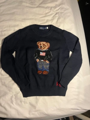 Mörkblå stickad Ralph Lauren tröja - Tröjan är knappt använd, skulle säga att det är en S-M då den krympt i tvätten och inte en XL som det står i nacken. Kolla gärna måttbilderna