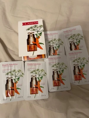 Clarins Double Serum Eye prover ca 6-7ml - Flera prover av Clarins Double Serum Eye, ett ögonserum med ingredienser som vild körvel och gurkmeja. Förpackningarna är små och smidiga, perfekta att testa eller ta med på resan. Serumet kommer i en brun och guldig design.