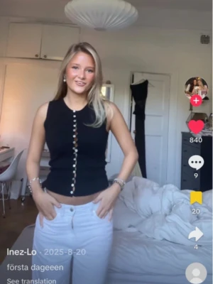 Svart croppad linnetopp med knappar - Säljer en svart croppad linnetopp med dekorativa knappar framtill. Toppen är ärmlös och har en slim passform som framhäver figuren. Perfekt för dig som gillar en enkel men snygg stil.