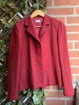 Röd kavaj från Parks i strl 38 - Stilren röd kavaj från Parks av Park Bravo i en klassisk retro design. Tre knappar framtill och två fickor som ger en chic look. Perfekt för dig som älskar vintage vibes och vill ha ett plagg som sticker ut men ändå är tidlöst. Lika snyggt till jeans som till kjol och klänning. Storlek 38 i mycket bra skick. 🎀