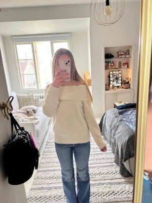 Vit off-shoulder stickad tröja - Säljer en vit stickad tröja med bred off-shoulder krage. Tröjan har långa ärmar och ribbade muddar vid ärmslut och nederkant. Perfekt för att skapa en avslappnad och trendig look. Storlek 140 men stor i storleken så passar  mig som har 158/164!💞💕💗