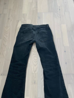 Svarta bootcut jeans med fickor - Säljer ett par svarta bootcut-jeans med låg midja och klassiska bakfickor. Modellen är lätt utsvängd nedtill, vilket ger en snygg och trendig look.  Jeansen är tillverkade i ett mjukt och stretchigt material som gör dem bekväma att bära hela dagen. Perfekta för en avslappnad men stilren look. Jeansen är uppsydda ca 1,5 cm. Jag på bilden är ca 162 cm lång. Ordinarie pris: 550 kr, kan diskutera pris.  Kolla in min profil för fler jeans & kläder. Hör gärna av dig om du har frågor eller liknande!