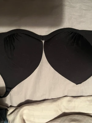 Svart push-up bh med bygel - En svart push-up bad bh med bygel och vadderade kupor. Bh:n har slät yta och diskret design utan spets eller mönster. Perfekt för en enkel och stilren look under kläderna.