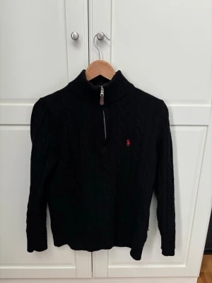 Svart polo Ralph lauren quarter zip stickad. - Hej! Jag säljer en svart stickad quarter zip tröja med röd broderad logotyp från Ralph lauren.