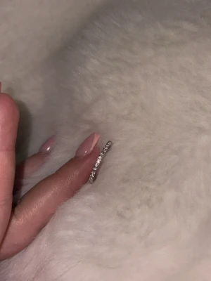 Tunn silverring med stenar - En stilren och tunn silverfärgad ring med små gnistrande stenar runt hela ringen. Perfekt för dig som gillar minimalistiska smycken med lite extra bling. Från Edblad. Köpt denna då jag tappa min andra men hittade min andra så den bara ligger på mitt bord. Helt ny! Inte använd alls storlek M
