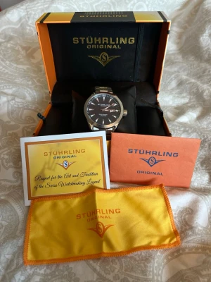 Stührling Original silverklocka - Stührling klocka – nyskick (aldrig använd)  Säljer en stilren och elegant klocka från Stührling i absolut nyskick. Klockan är helt oanvänd och har en snygg mörkblå urtavla som ger ett exklusivt och tidlöst intryck.  Alla tillbehör och bevis på äkthet medföljer självklart, inklusive originalförpackning.  Nypris ligger på cirka 1499 kr. Pris: [899kr] – kan diskuteras vid snabb affär.  Perfekt både till vardag och finare tillfällen.  Hör av dig vid intresse eller frågor!
