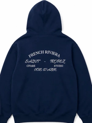 Mörkblå hoodie från Civare Studio - Mörkblå hoodie med tryck på ryggen och liten logga fram. Stora vita bokstäver på ryggen med texten 'French Riviera', 'Saint-Tropez', 'Civare Studio' och 'Côte d'Azur'. Klassisk känguruficka och dragsko i huvan. Skön bomullskänsla.
