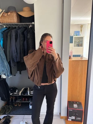 Brun mockajacka från Zara - Snygg brun mockajacka med dragkedja framtill och avslappnad passform. Jackan har breda ärmar och klassisk krage, perfekt för dig som gillar en loose och trendig stil. Jackan är från Zara, aldrig använd med prislapp på i storlek M.