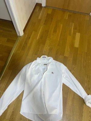 Vit skjorta från Burberry XL - Klassisk vit skjorta från Burberry i storlek XL. Skjortan är långarmad .Perfekt för sommarn 
