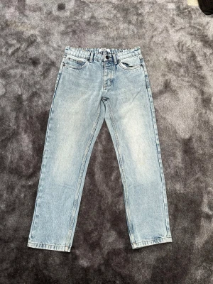Ljusblå raka jeans från fsbn  - Säljer ett par ljusblå raka jeans från fsbn med klassisk femficksdesign. Jeansen har en avslappnad passform och är tillverkade i bomull. Perfekta för en chill och trendig look. Storlek 29/30