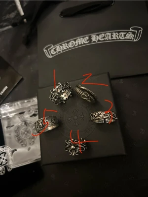 Chrome Hearts silverringar set - STYCK PRIS ÄR DET MEN KAN GÖRA DEALS VID KÖP AV FLERA, SKRIV 😃😆 ~Säljer ett set med fem unika silverringar från Chrome Hearts. Ringarna har detaljerade gravyrer, korsmotiv och ornamentala mönster. Alla ringar är i robust silverfärg och har en cool, edgy design som sticker ut. Perfekt för dig som gillar statement-smycken och streetwear-vibe.