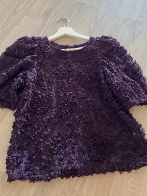 Lila blommig blus med puffärm - Mörklila blus med blomdetaljer. Endast använd 1 gång.💕