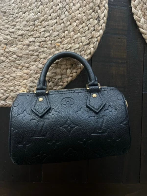  svart handväska i läder - Snygg svart handväska, guldfärgade metalldetaljer. Perfekt storlek för det viktigaste och en tidlös design.