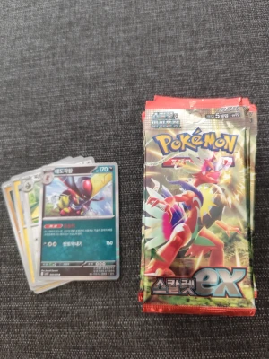 Pokémon Scarlet ex boosterpaket - Säljer flera boosterpaket från Pokémon Scarlet ex-serien. Paketen är färgglada med illustrationer av Pokémon och innehåller samlarkort. Perfekt för dig som vill utöka din samling eller spela TCG. Några kort visas också på första bilden. 14 packs + ett som är öppnat 