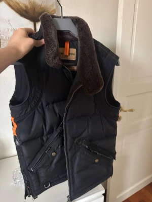 Svart dunväst Parajumpers med päls - Säljer min väst som inte kommer till någon användning längre. Den är i bra skick och det är inget fel på västen, modellen på västen finns inte kvar längre och är sällsynt,  hör av er för mer information.
