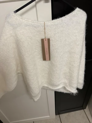 Vit stickad tröja från Marta - Supermjuk och fluffig vit stickad tröja från Marta. Tröjan har en lös passform, rund halsringning och långa ärmar. Perfekt för lager-på-lager och riktigt cozy vibes. Materialet känns lätt och luftigt, med en diskret struktur i stickningen.