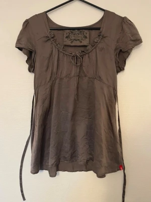 Babydoll silkesblus  - Söt silkes blus med korta puffärmar och rundad halsringning. Knytband i bak som är fäst under bysten som tillåter dig att få en chic babydoll topp! Den är i storlek 36/S från EDC by Espirit