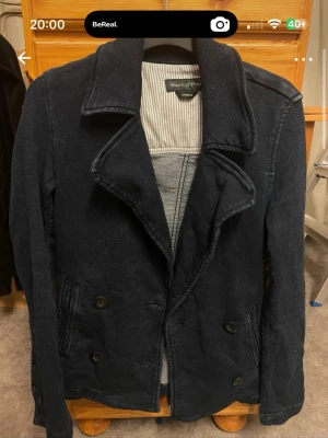 Marinblå dubbelknäppt jeansjacka Marc O'Polo - Snygg marinblå jeansjacka/kavaj från Marc O'Polo med dubbelknäppning och bred krage. Rocken har två framfickor och är tillverkad i ett kraftigare tyg, perfekt för kyligare dagar. Insidan har ett randigt foder som ger en stilren kontrast. Aldrig använd💙💙💙