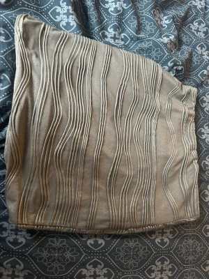 Grå kjol med vågigt mönster från ONLY - Säljer en grå kjol från ONLY med snyggt vågigt strukturmönster. Kjolen har en rak och kort modell med elastisk midja för skön passform. Materialet är glansigt och ger ett elegant intryck. Perfekt för dig som vill ha något stilrent och trendigt.