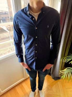 Marinblå Ralph lauren skjorta slim fit - Säljer en riktigt go ralph lauren skjorta perfekt nu till våren och sommaren nu när det börjar bli varmare. Skjortan är storlek S slim fit och han på bilden är 185 och väger 75 kg. Hör gärna av er vid funderingar mvh Ae💯