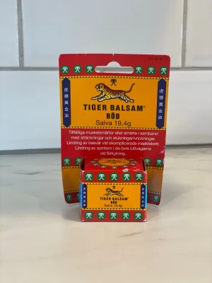 Tiger Balsam Röd salva 19,4g - Tiger Balsam Röd är en klassisk salva i en liten glasburk med röd och gul förpackning. Används för tillfällig lindring av muskelvärk, stukningar och insektsbett. Innehåller naturliga oljor och har en stark doft av mentol och kamfer.