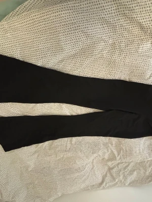 Svarta leggings från Gina Tricot - Säljer ett par klassiska svarta bootcut leggings från Gina Tricot. De har hög midja och är tillverkade i ett stretchigt material av bomull och elastan, vilket gör dem riktigt bekväma och perfekta till alla outfits. Enkla att matcha och ett måste i garderoben!💕