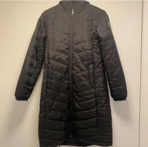 Svart lång jacka/kappa - Säljer en svart lättviktsjacka från Deval i storlek small. Jackan är lång med dragkedja framtill. Den har en praktisk huva och långa ärmar. Passar både till vardags och lite finare tillfällen. den är endast använd 3 gånger så den är i nyskick. Perfekt till vår och alla årstider🤗