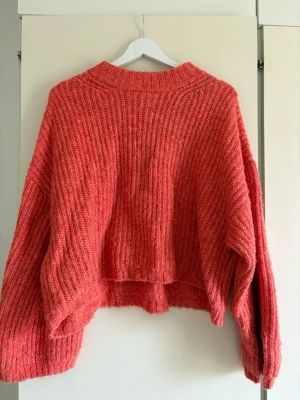 Rosa stickad tröja Gina Tricot - Rosa stickad tröja från Gina Tricot. Tröjan har bred ribbstickning, långa ärmar och en något croppad passform. 