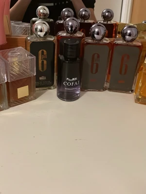 Final Cofaj parfymflaska - Snygg parfymflaska från Final Cofaj i svart och lila glas med elegant design. Flaskan har en rundad form och svart lock. Perfekt för dig som gillar stilrena och moderna dofter att ha på hyllan.