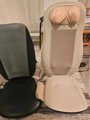 2 st Massagekuddar för stol nytt oanvänt  - Två massagekuddar för stol i svart och beige. Ena har mesh-tyg och konstläder, den andra är helsvart med mesh-panel. Båda har elsladdar och är utformade för rygg och nacke. Perfekt för att slappna av hemma eller på kontoret.